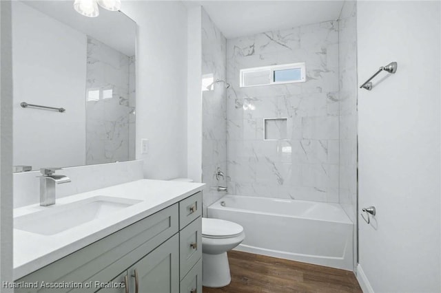 full bathroom with wood-type flooring, toilet, vanity, and tiled shower / bath