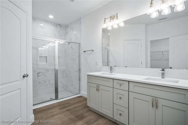 bathroom featuring wood-type flooring, a shower with door, and vanity