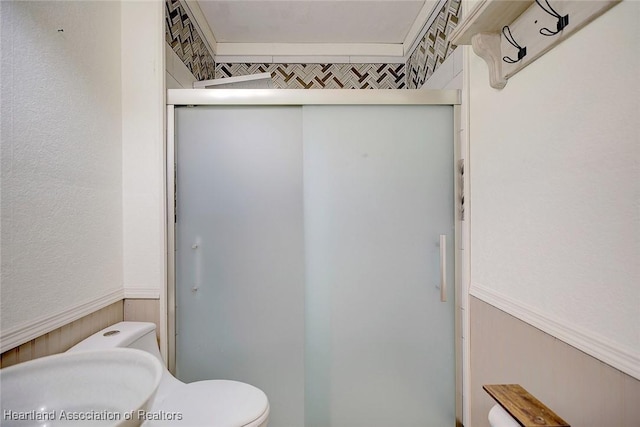 bathroom featuring an enclosed shower and toilet