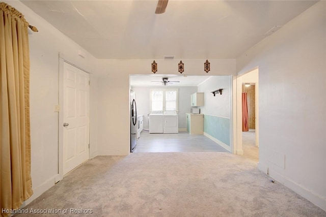 interior space featuring ceiling fan, light colored carpet, and independent washer and dryer