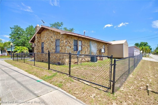 view of front of home with central AC unit and a front yard