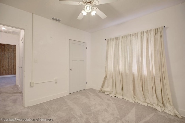 unfurnished bedroom with ceiling fan and light colored carpet