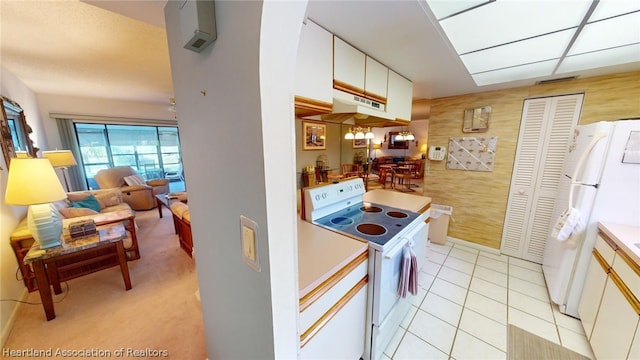 kitchen featuring light tile patterned floors, white appliances, and white cabinetry