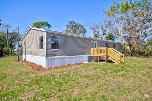 exterior space featuring a wooden deck and a lawn