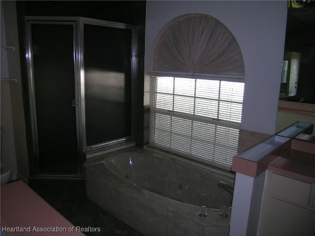 full bathroom featuring a stall shower and a tub with jets