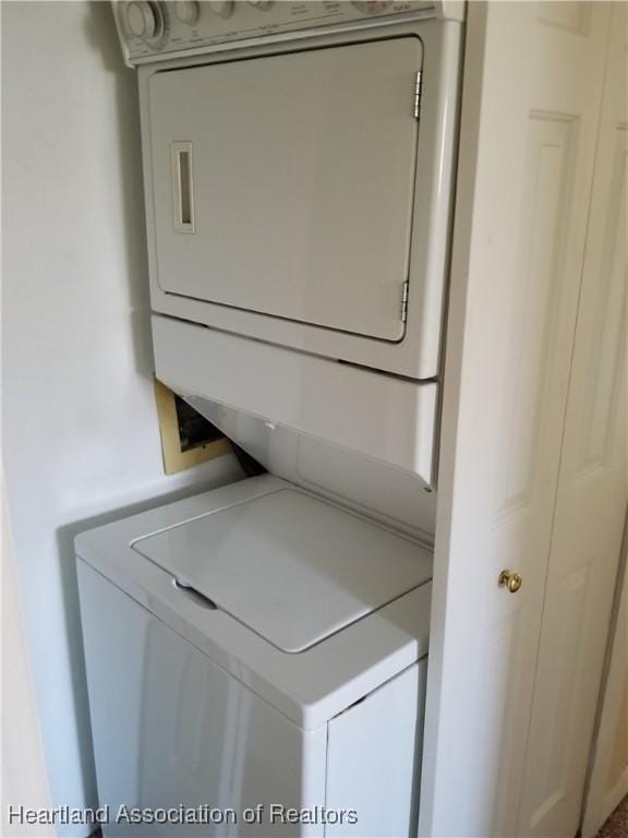 clothes washing area with laundry area and stacked washer and clothes dryer