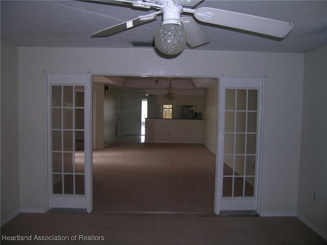 carpeted spare room featuring french doors, visible vents, ceiling fan, and baseboards