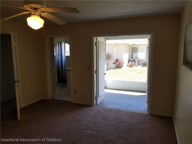 interior space with plenty of natural light, baseboards, ceiling fan, and a textured ceiling