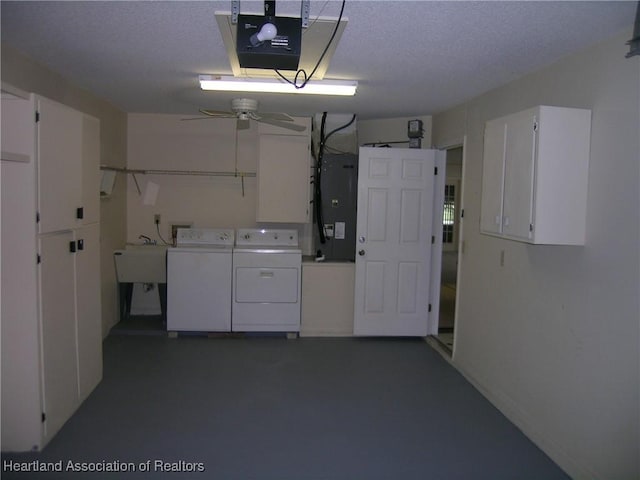 garage with a garage door opener, a sink, and washing machine and clothes dryer