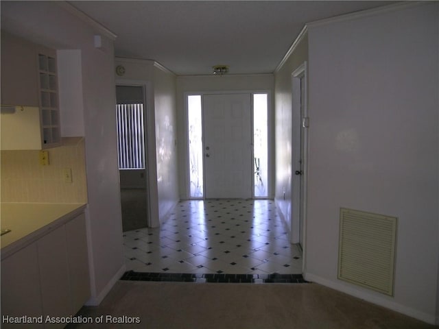 foyer featuring ornamental molding, visible vents, and baseboards