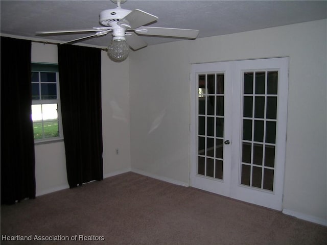 carpeted empty room featuring ceiling fan and french doors