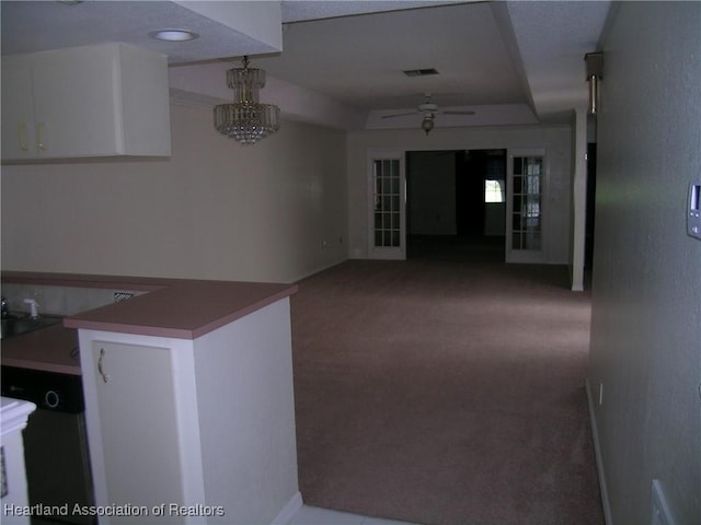 hallway with carpet, visible vents, a notable chandelier, and baseboards