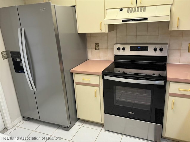 kitchen featuring appliances with stainless steel finishes, tasteful backsplash, light tile patterned floors, and extractor fan