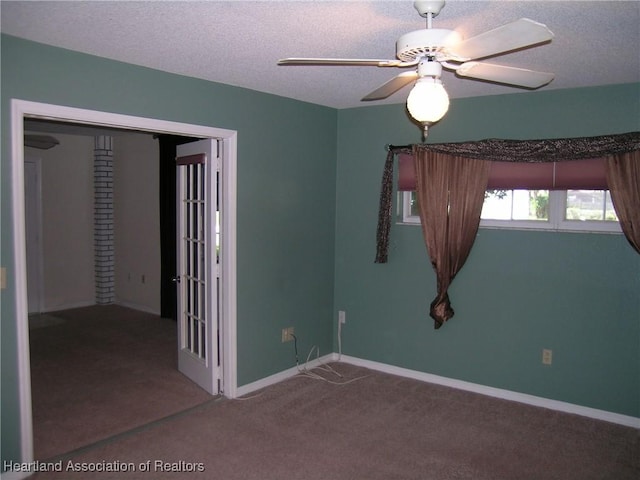 unfurnished room featuring baseboards, carpet, a ceiling fan, and a textured ceiling