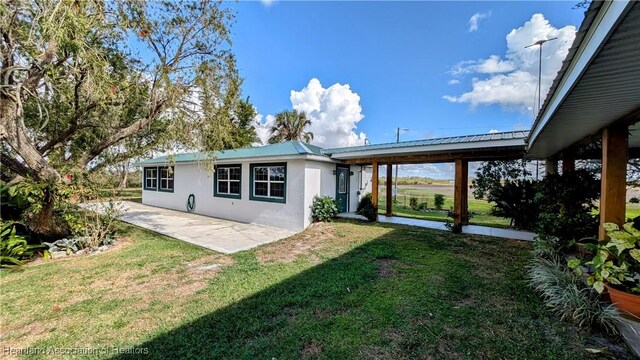 back of property with a patio and a lawn