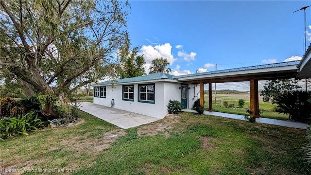 back of house featuring a yard and a patio