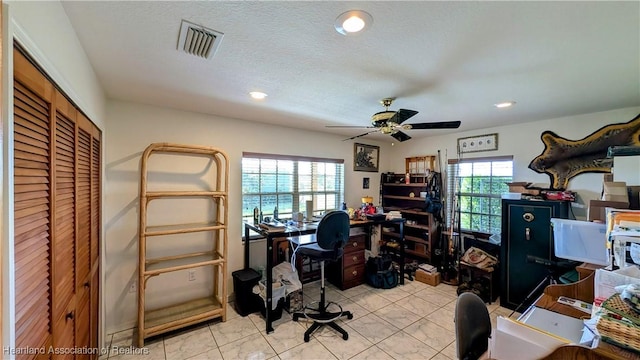 home office with plenty of natural light, ceiling fan, light tile patterned flooring, and a textured ceiling