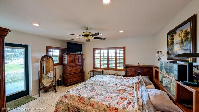 tiled bedroom featuring multiple windows and ceiling fan