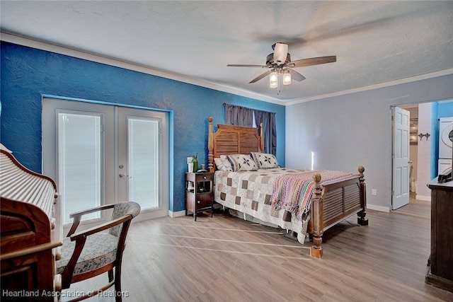 bedroom with french doors, stacked washing maching and dryer, ornamental molding, ceiling fan, and hardwood / wood-style flooring