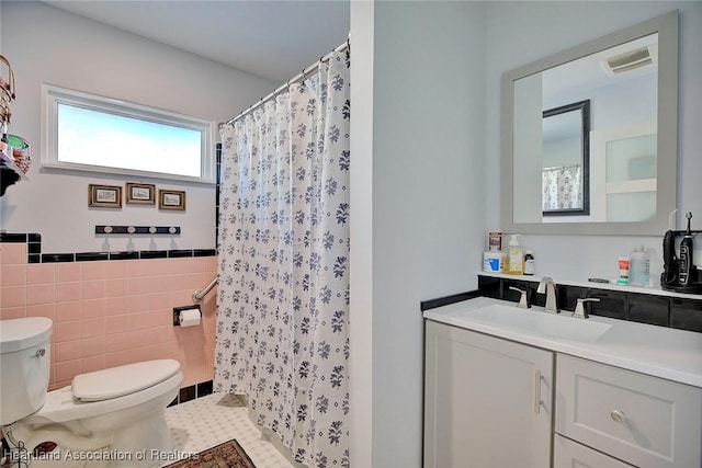 bathroom featuring vanity, tile patterned floors, toilet, tile walls, and curtained shower