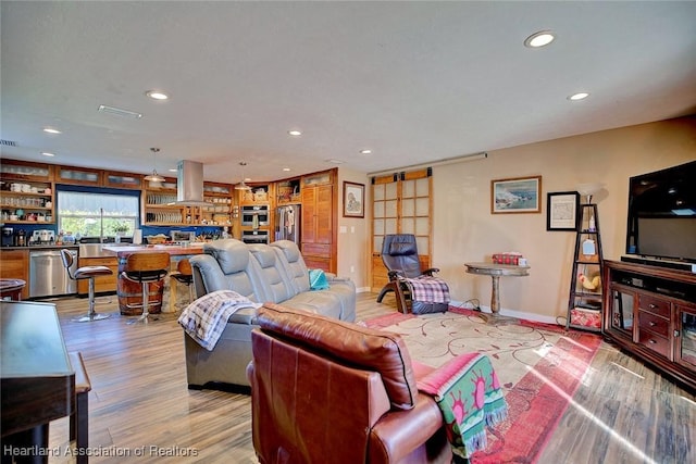 living room with built in features and light hardwood / wood-style flooring