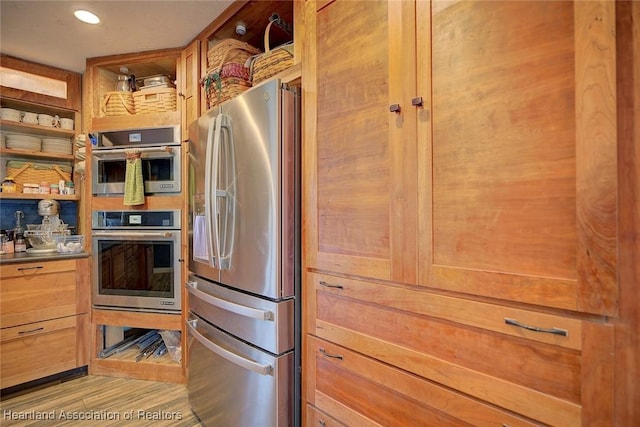 kitchen with stainless steel appliances and light hardwood / wood-style floors