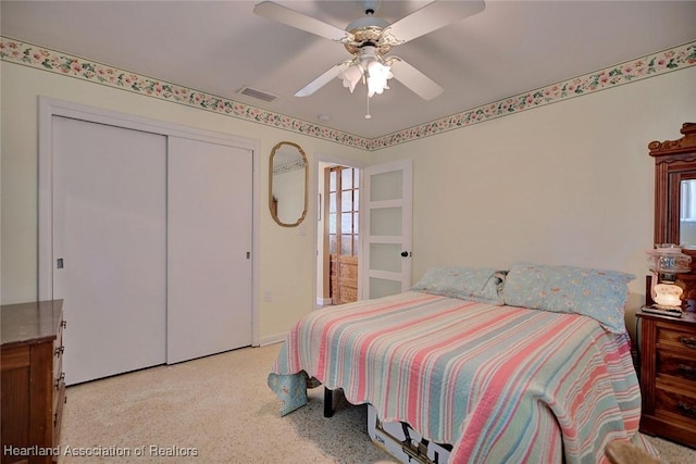 bedroom featuring ceiling fan, light colored carpet, and a closet