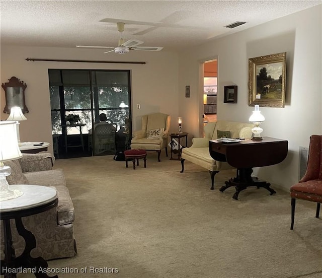 living room featuring ceiling fan, carpet, and a textured ceiling