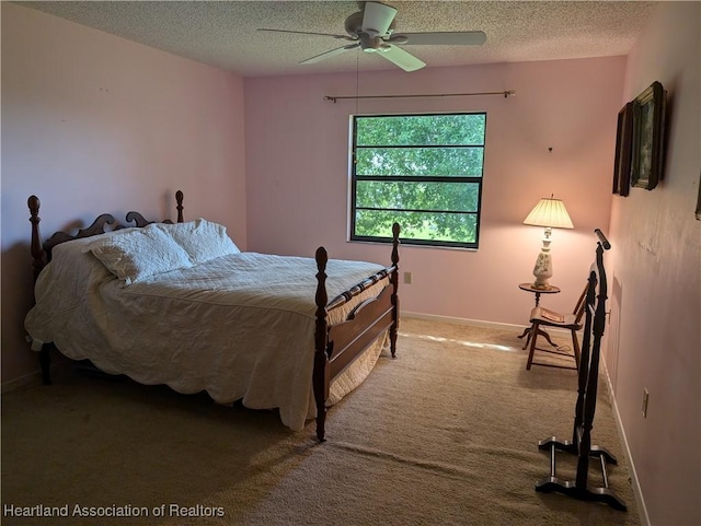 bedroom featuring carpet flooring, ceiling fan, and a textured ceiling