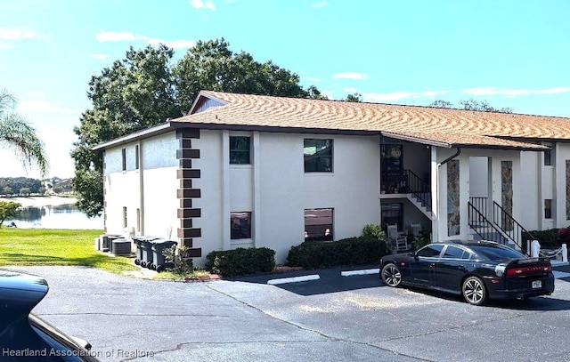 view of building exterior with a water view and central AC