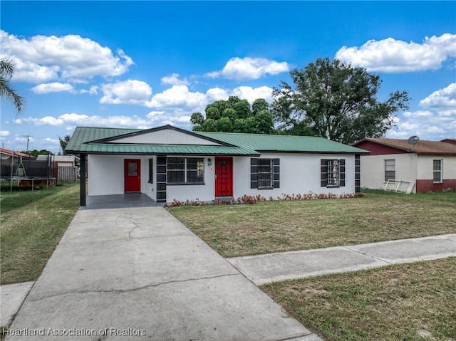 ranch-style house with a front yard, a trampoline, and a carport