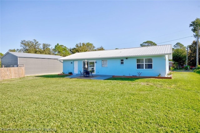 rear view of house with a yard and a patio