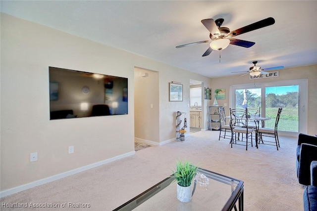 carpeted living room featuring ceiling fan