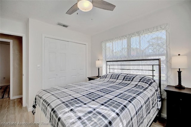 bedroom featuring ceiling fan, a closet, and light wood-type flooring