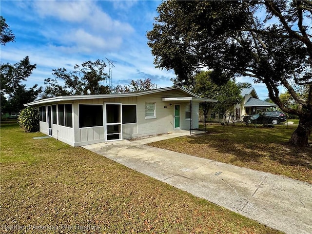 view of front of property with a sunroom and a front yard