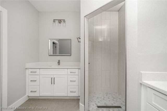 bathroom featuring vanity, tile patterned floors, and tiled shower