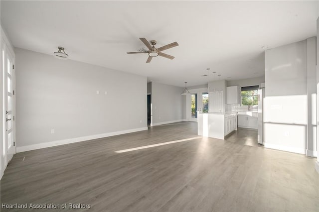 empty room with dark wood-type flooring and ceiling fan