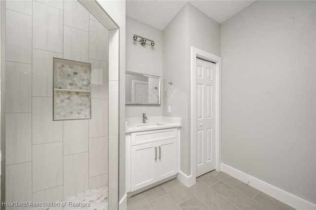 bathroom featuring vanity, tiled shower, and tile patterned floors