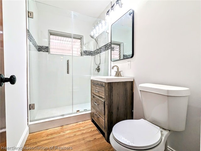 bathroom featuring vanity, hardwood / wood-style flooring, toilet, and walk in shower