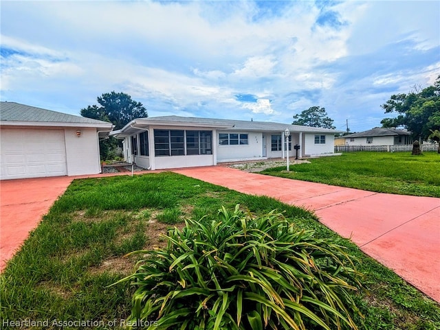 single story home with a sunroom, a front lawn, and a garage