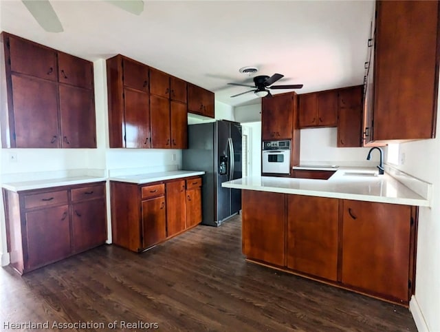 kitchen featuring dark wood-type flooring, white oven, black fridge, sink, and ceiling fan