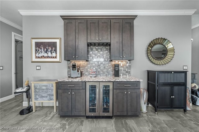 bar featuring dark brown cabinets, decorative backsplash, ornamental molding, and beverage cooler