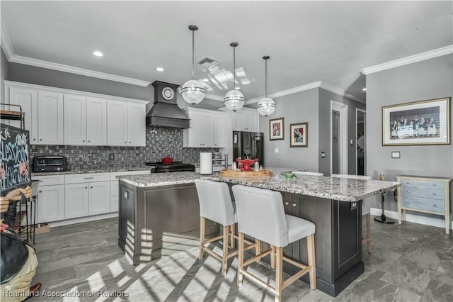 kitchen featuring white cabinets, custom range hood, black refrigerator with ice dispenser, and a large island with sink