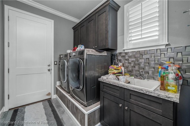 laundry room with washer and clothes dryer, cabinets, ornamental molding, and sink