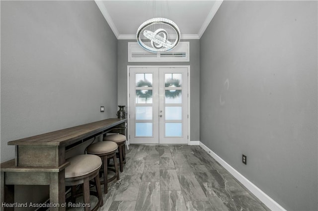 doorway with a chandelier, ornamental molding, and french doors