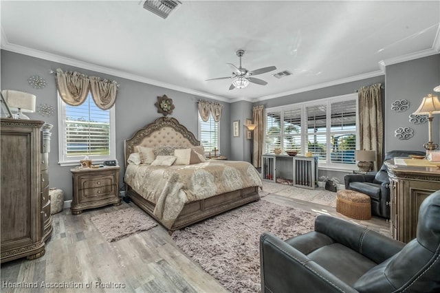 bedroom featuring multiple windows, ceiling fan, wood-type flooring, and ornamental molding