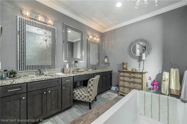 bathroom with a bath, vanity, and ornamental molding