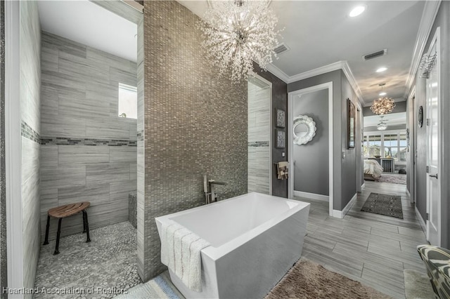 bathroom with a bath, crown molding, a chandelier, and a tile fireplace