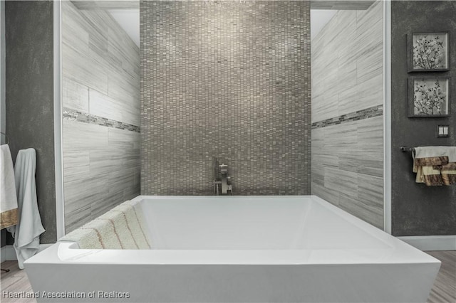 bathroom with a bath and wood-type flooring