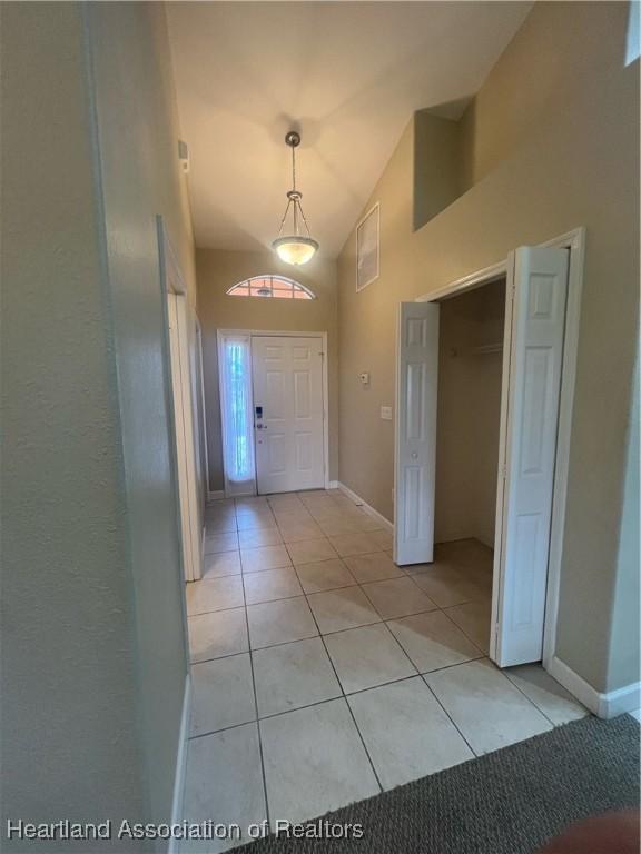 interior space featuring light tile patterned floors and lofted ceiling